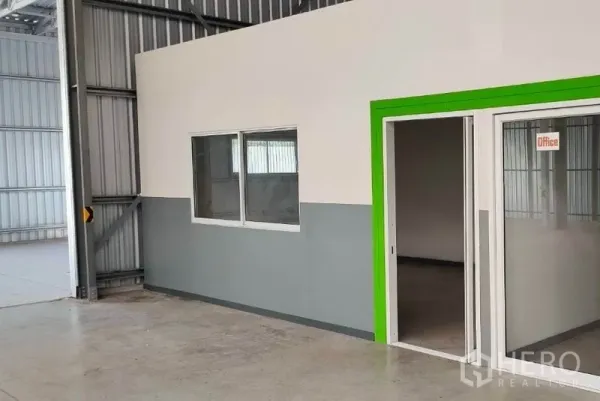 Warehouse for rent in Pak Kret, Nonthaburi - Internal office room with sliding glass door and window inside the warehouse.