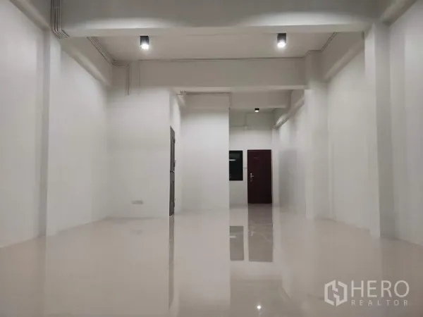 Home Office for sale in Lam Luk Ka, Pathum Thani - Ground-floor open-plan space with white walls and glossy tiled floor.