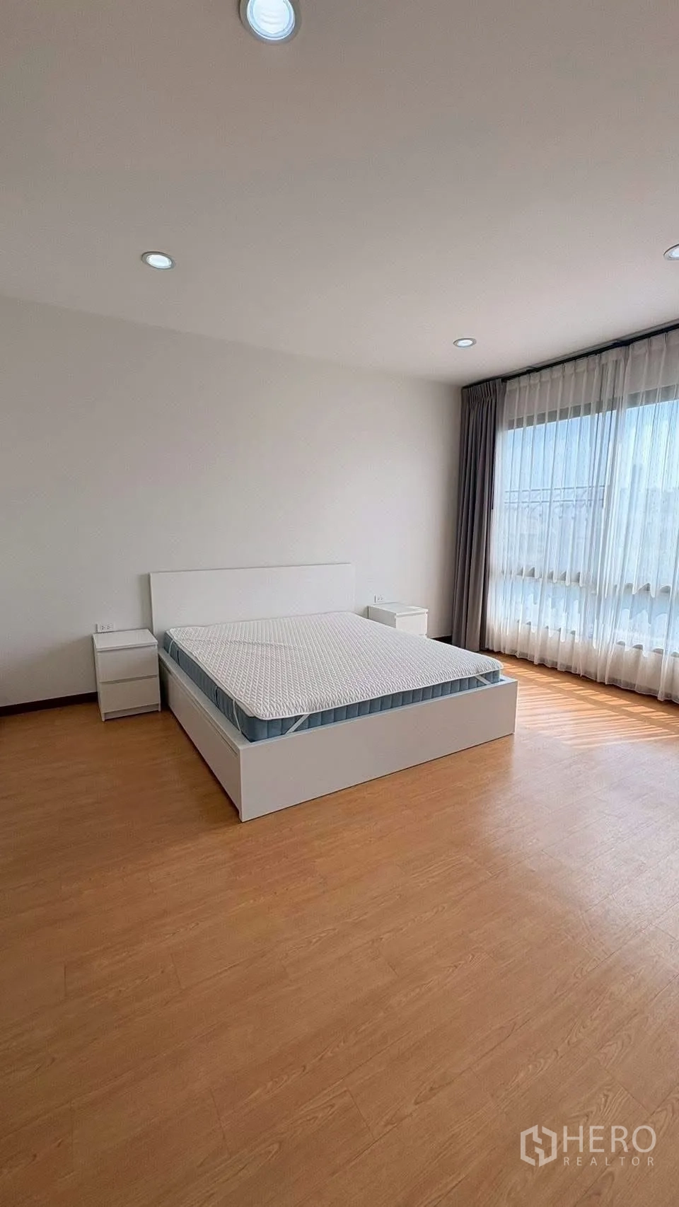 联排别墅 for rent in Phra Khanong, Bangkok - 采光充足的卧室，配床与透光纱帘。