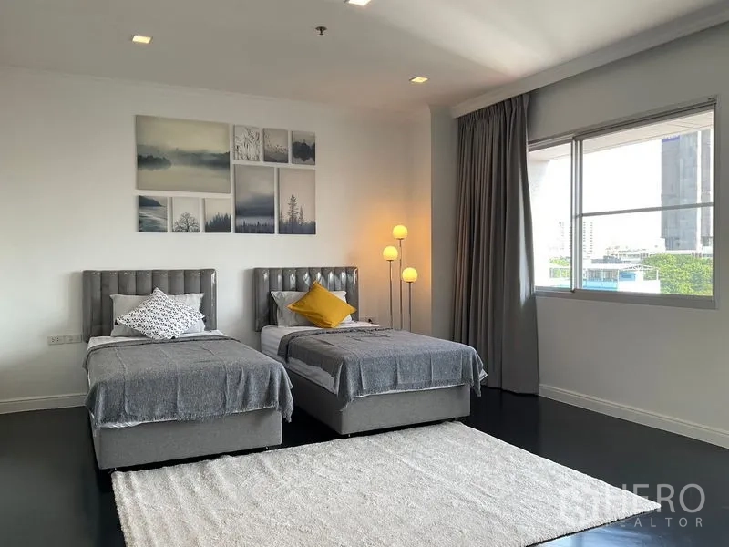 房间 出租在Sathon, Bangkok - 客卧两张单人床，墙面装饰画与大窗。