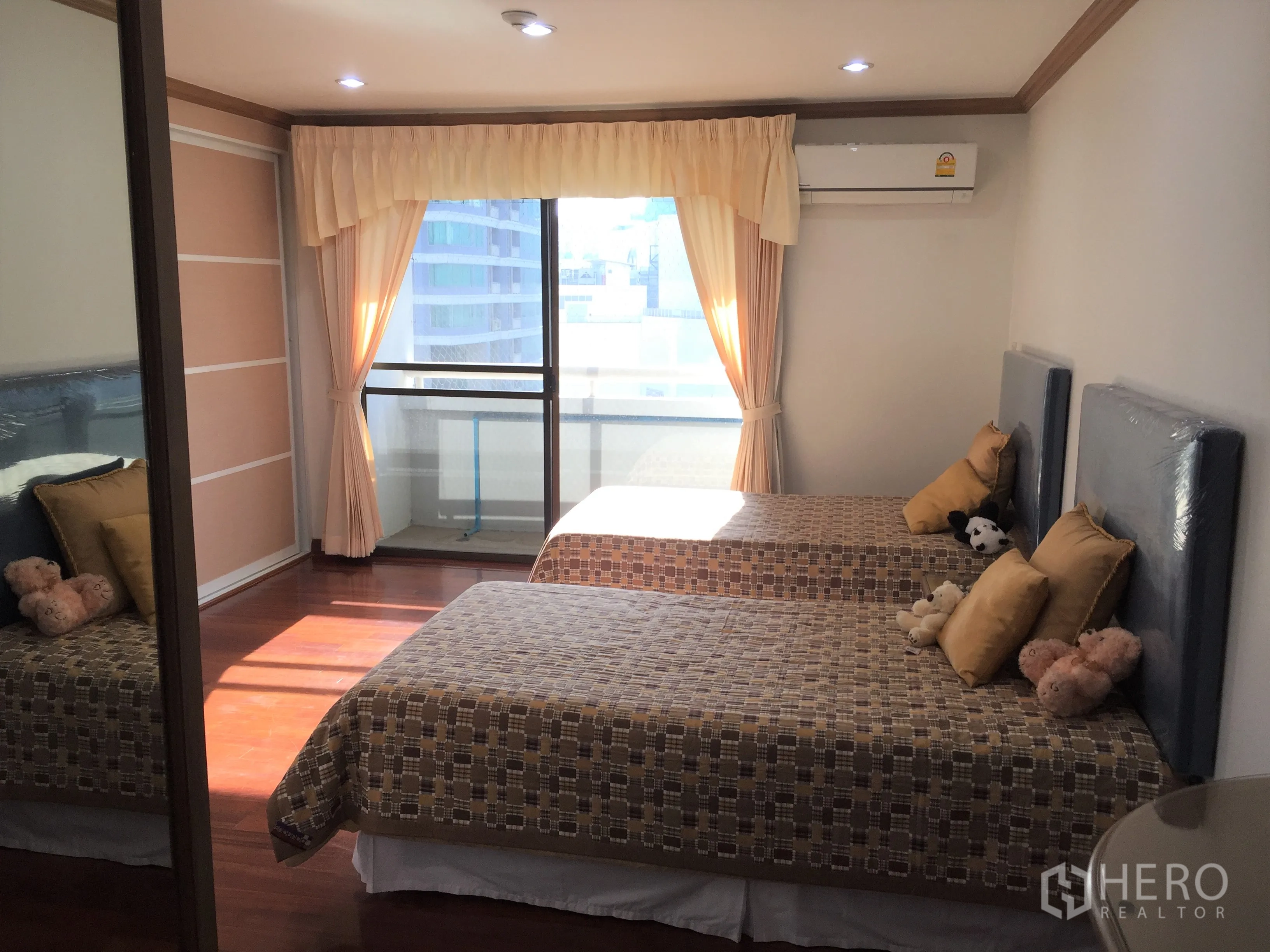 Condominium for rent in Watthana, Bangkok - Twin bedroom with two single beds, balcony access through sliding glass doors and soft curtains.