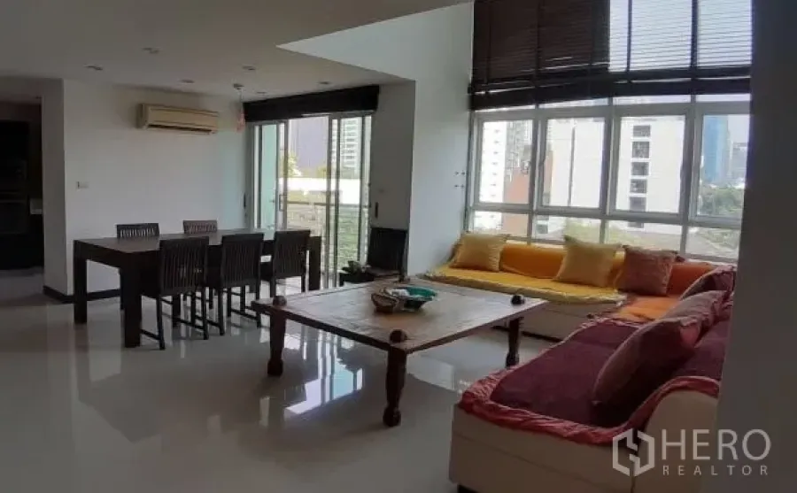 Condominium for rent in Watthana, Bangkok - Sunny open-plan living and dining room with large windows, city views and a built-in window bench.