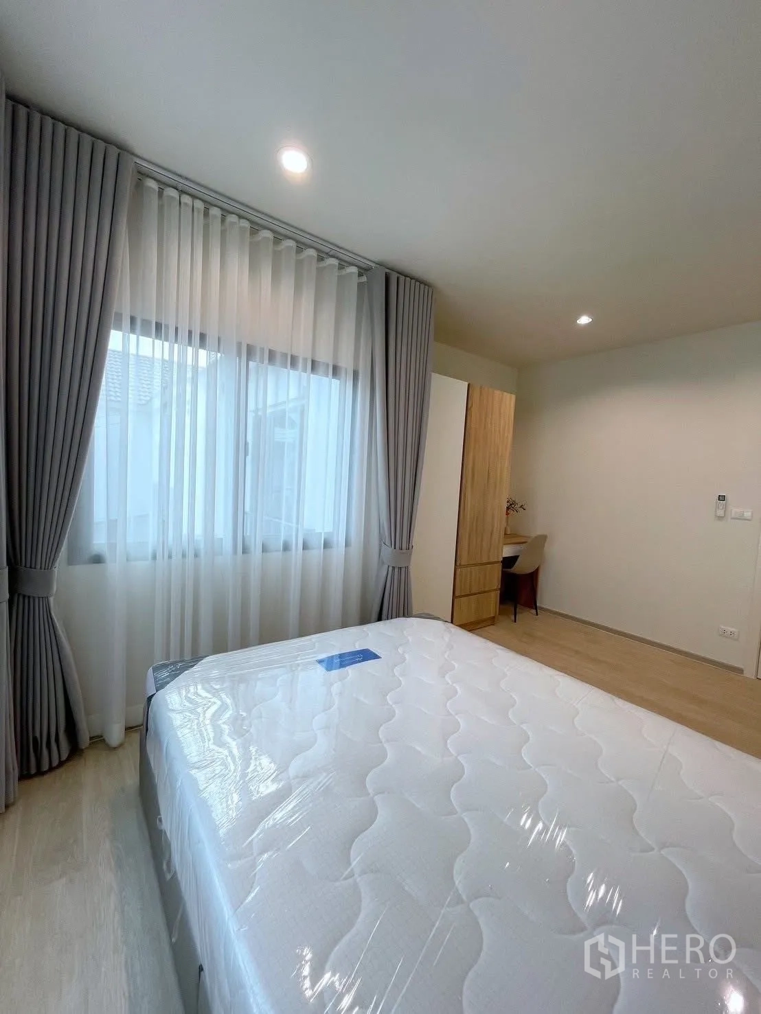 Detached House for rent in Bang Phli, Samut Prakan - Bright bedroom with large window, sheer curtains, and a new queen bed on light wood floors.