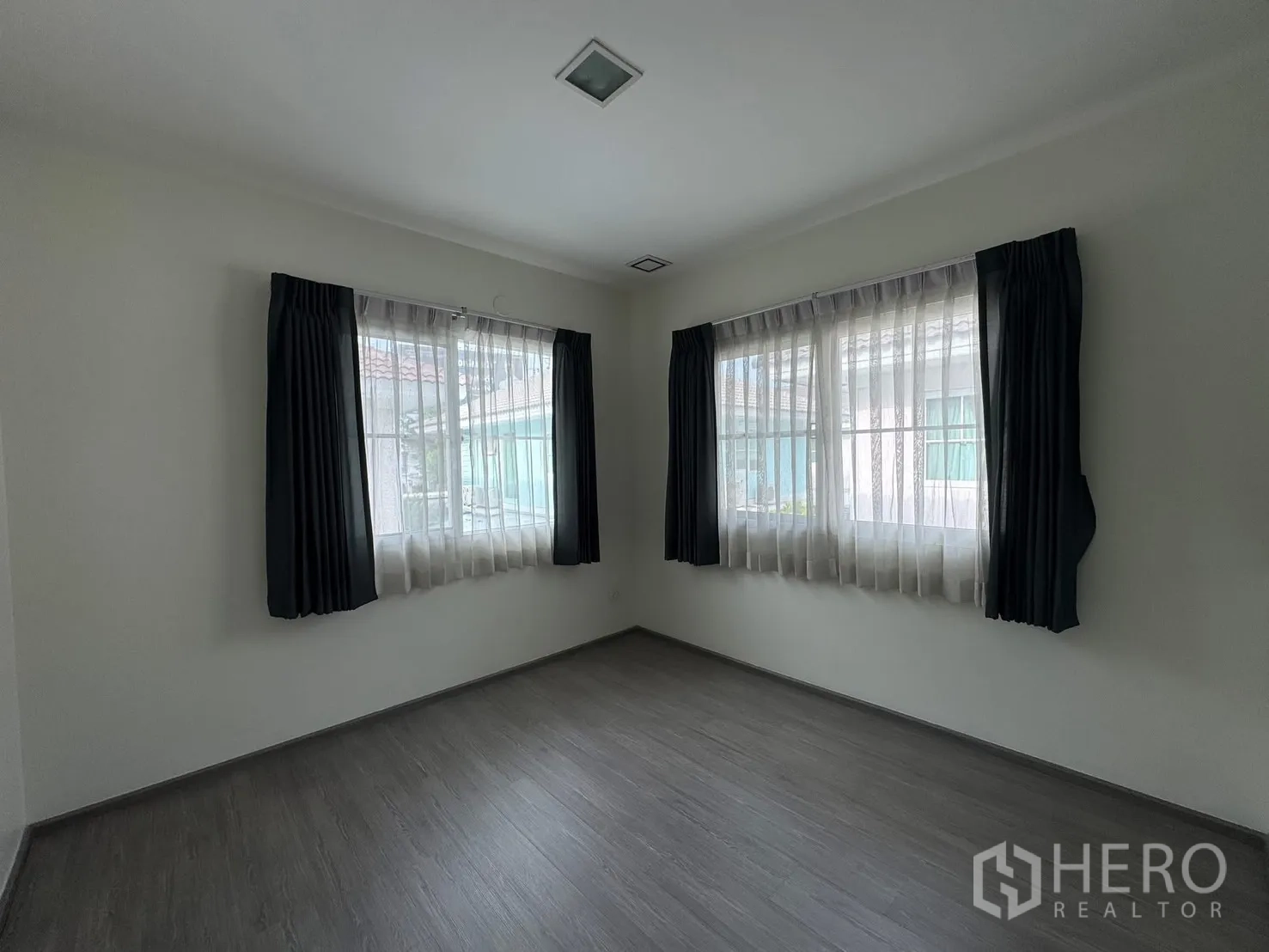 Detached House for rent in Bang Phli, Samut Prakan - Empty corner bedroom with two wide windows and double-layer curtains.