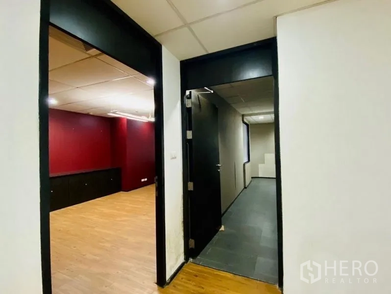 สำนักงาน ให้เช่าหรือขายในWatthana, Bangkok - ทางเดินสู่ห้องทำงานผนังสีแดง พื้นไม้ กรอบประตูสีดำ