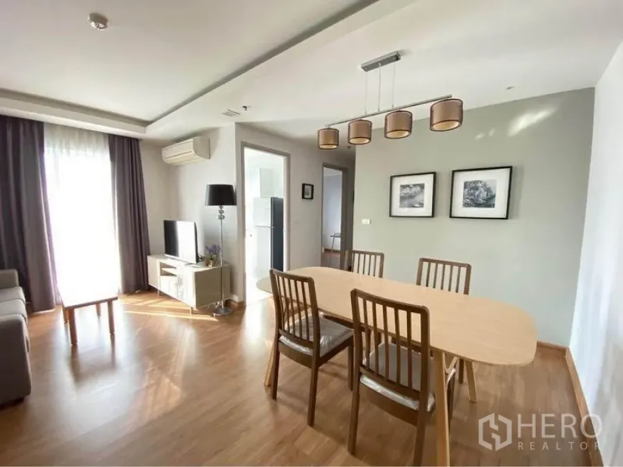 Condominium for rent in Huai Khwang, Bangkok - Spacious dining area with four chairs and doorway to the kitchen.