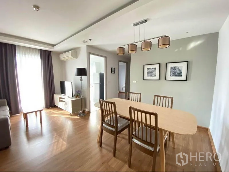 Condominium for rent in Huai Khwang, Bangkok - Spacious dining area with four chairs and doorway to the kitchen.