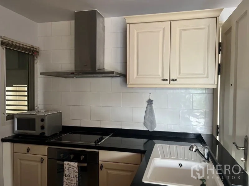 คอนโด ให้เช่าในSathon, Bangkok - มุมครัวพร้อมเตาไฟฟ้า เครื่องดูดควัน ไมโครเวฟ ตู้แขวนสีครีม และอ่างล้างจาน