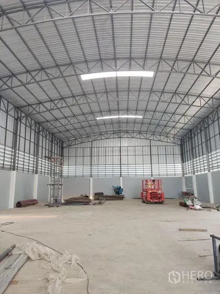 Factory for sale in Krathum Baen, Samut Sakhon - Spacious high-ceiling warehouse interior with steel truss roof, vents, and open floor space.