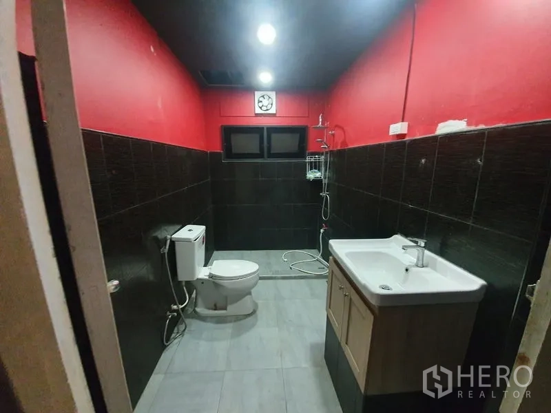 อาคารพาณิชย์ ให้เช่าในKhlong Toei, Bangkok - ห้องน้ำผนังสีแดง กระเบื้องสีดำ มีฝักบัว โถสุขภัณฑ์ และอ่างล้างหน้า