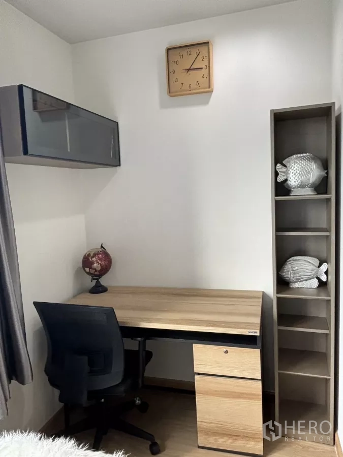Condominium for rent in Phra Khanong, Bangkok - Workstation corner with wooden desk, shelving and wall clock.