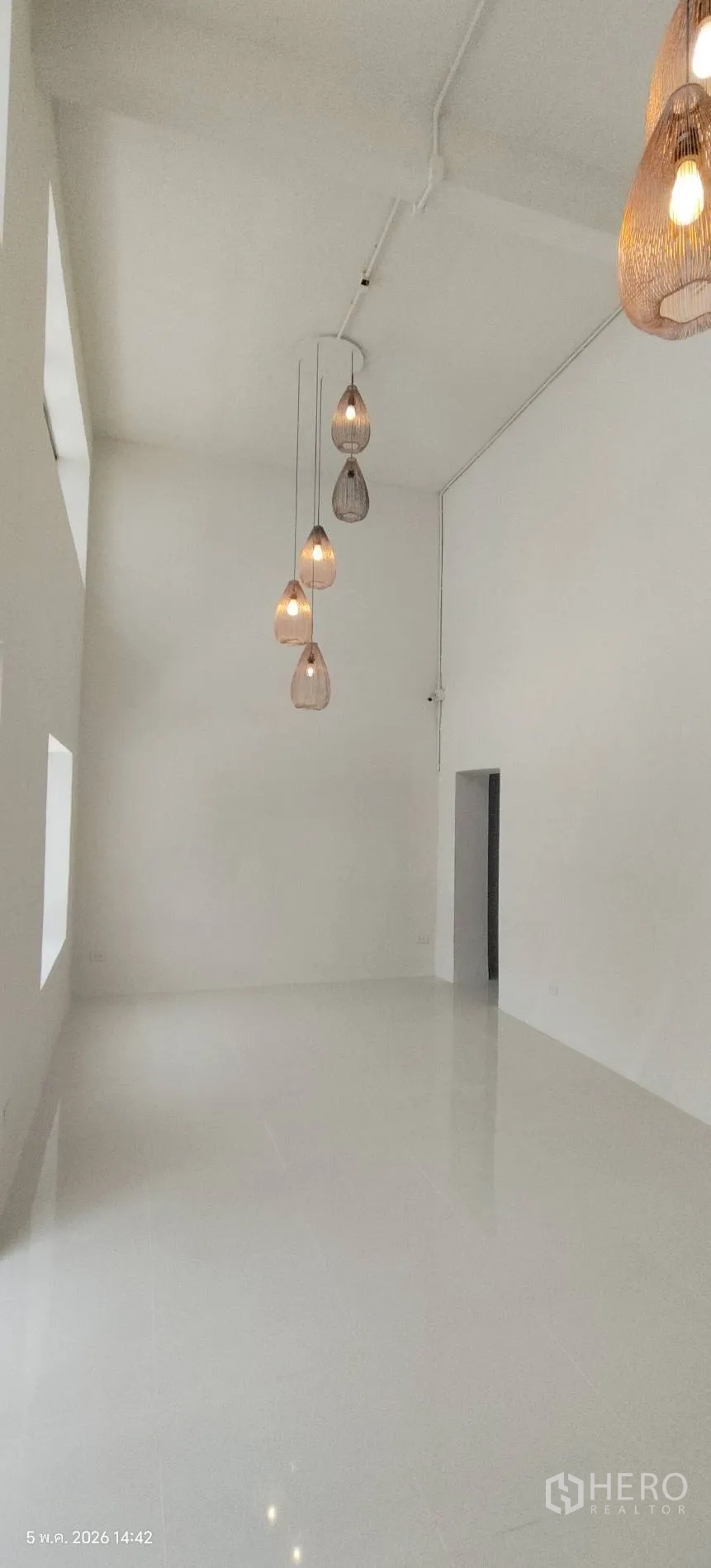ตึกแถว for rent in Watthana, Bangkok - โถงโชว์รูมเพดานสูงผนังขาวประดับโคมแขวน