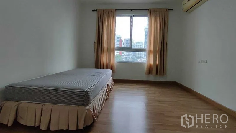 คอนโด ให้เช่าในKhlong Toei, Bangkok - ห้องนอนแขกพร้อมเตียงเดี่ยว หน้าต่างวิวเมือง พื้นไม้ และเครื่องปรับอากาศ