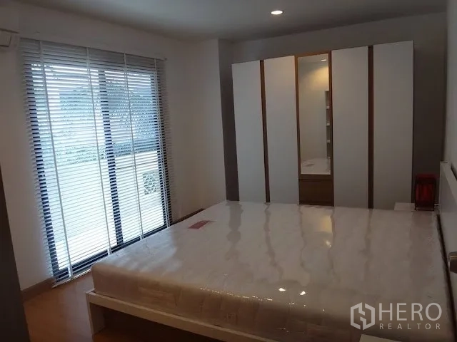 公寓 出租在Bang Rak, Bangkok - 卧室配推拉玻璃门、百叶窗、白色衣柜与平台床，木地板。