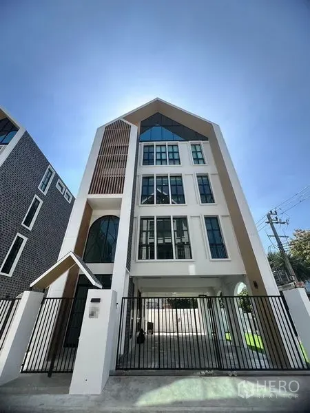 สำนักงานที่บ้าน ให้เช่าในBang Kapi, Bangkok - อาคารโฮมออฟฟิศทรงจั่วร่วมสมัย หน้าต่างสูง และประตูรั้วหน้าบ้าน.