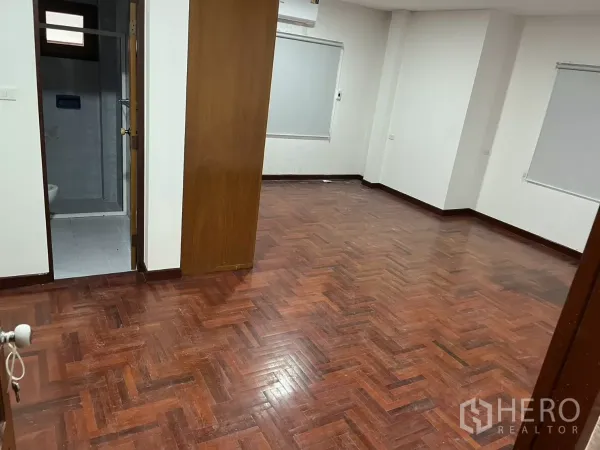 บ้าน ให้เช่าในWatthana, Bangkok - ห้องขนาดใหญ่ปูพื้นปาร์เกต์ ผนังสีขาว พร้อมประตูเชื่อมเข้าสู่ห้องน้ำ.