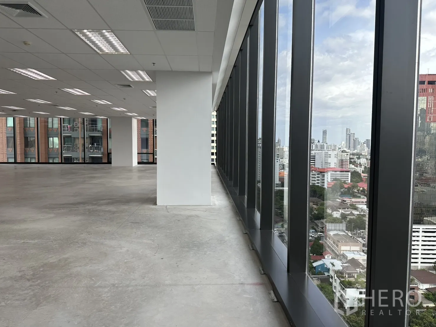 Office Space for rent in Ratchathewi, Bangkok - Close-up of perimeter glass wall with skyline outlook along the corridor.