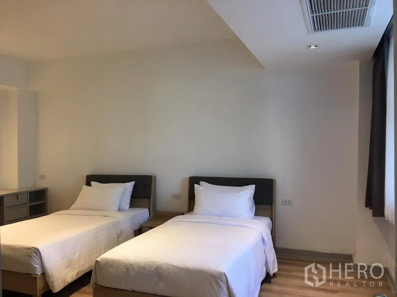 อพาร์ทเมนท์ ให้เช่าในKhlong Toei, Bangkok - ห้องนอนที่สองมีเตียงเดี่ยวสองเตียง พื้นไม้ และผ้าม่านทึบแสง