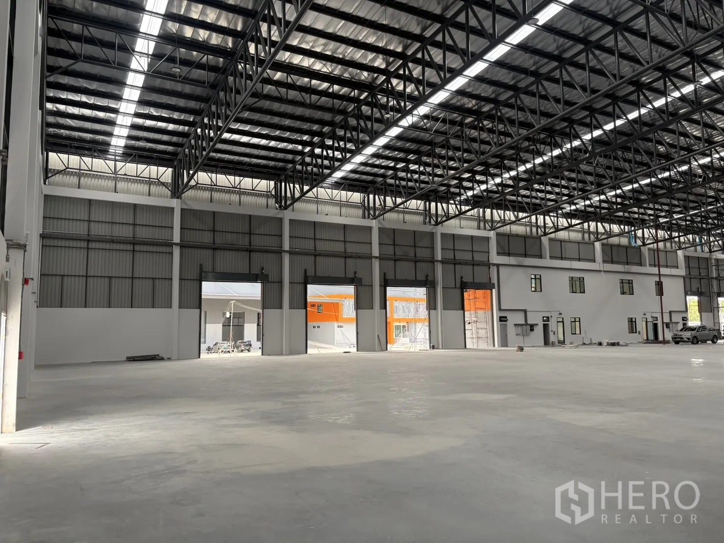 Factory for rent in Bang Pakong, Chachoengsao - Warehouse interior showing multiple roller shutter doors and side offices.