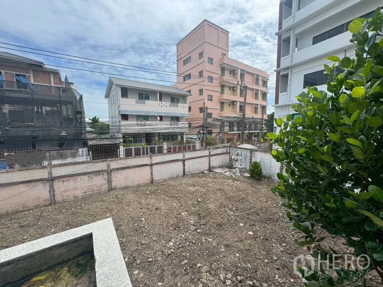 Detached House for rent or sale in Watthana, Bangkok - View over the cleared plot from an upper level toward neighboring buildings.