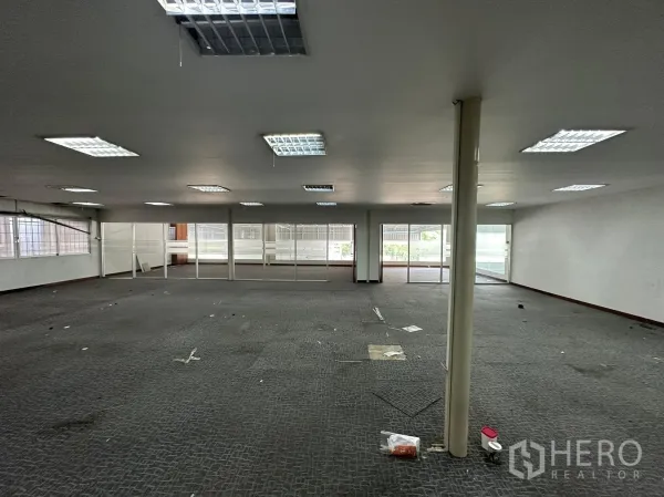 Warehouse for rent in Huai Khwang, Bangkok - Large open-plan office with carpet, drop ceiling lights and glass partitions.