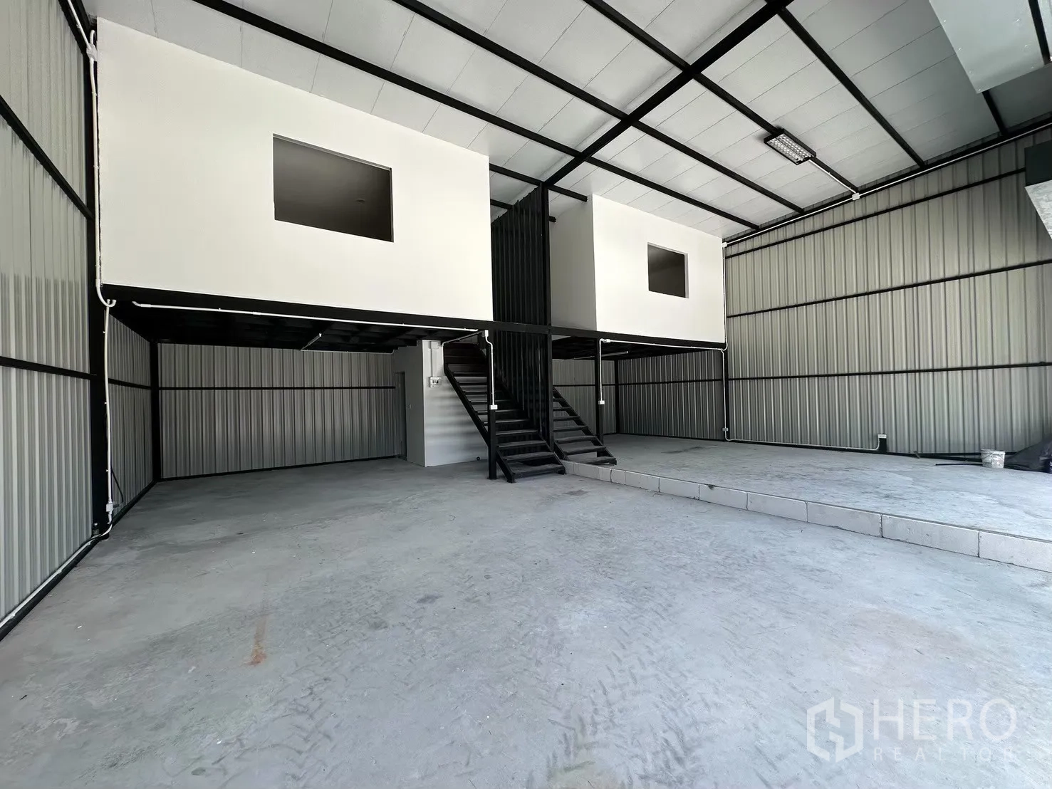 Warehouse for rent in Prawet, Bangkok - Open-plan warehouse floor showing steel structure, mezzanine boxes and stair access.