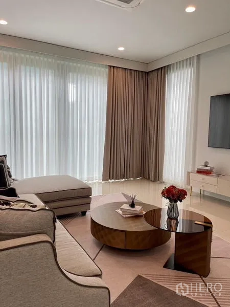 Detached House for rent or sale in Bang Kapi, Bangkok - Bright living room with sectional sofa, coffee tables and TV wall.