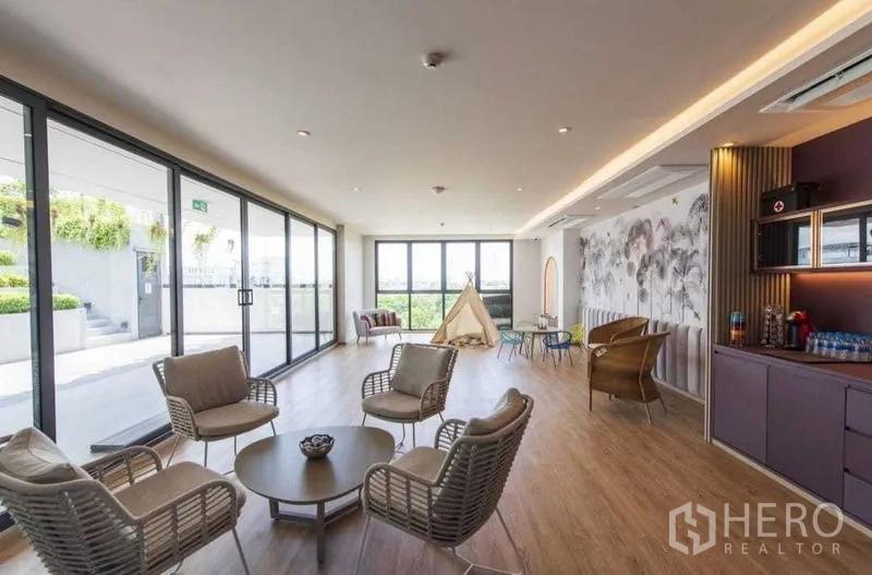 Detached House for rent or sale in Khan Na Yao, Bangkok - Community lounge with floor-to-ceiling windows opening to terrace and greenery.