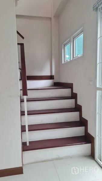 联排别墅 for 在Lam Luk Ka, Pathum Thani - 靠窄窗的楼梯通往上层。