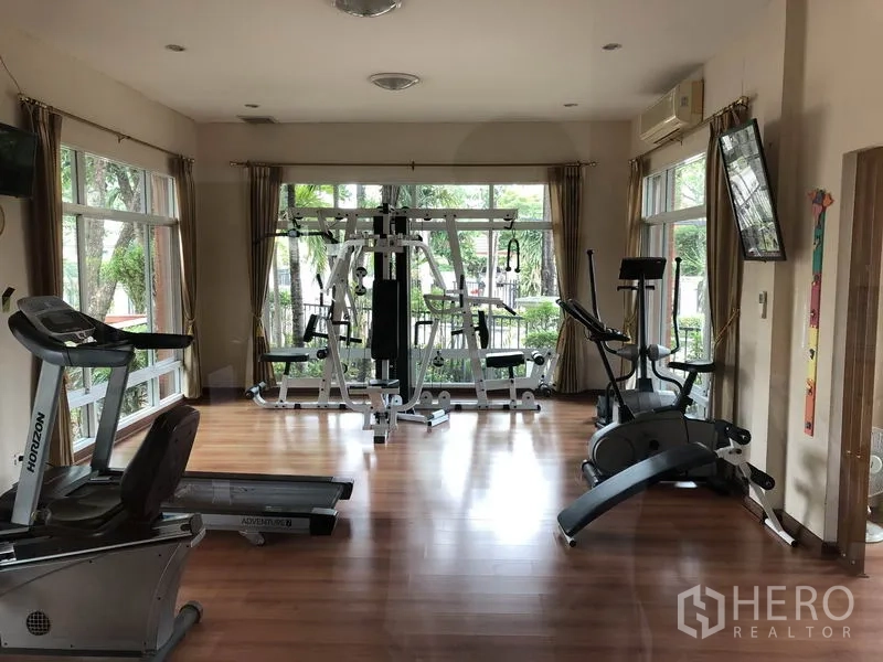Detached House for rent in Saphan Sung, Bangkok - Residents’ fitness room with treadmills, bikes and weight machines facing large windows.