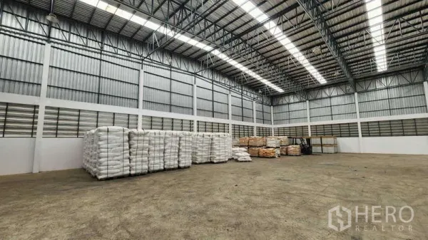 货栈 出租在Ban Phaeo, Samut Sakhon - 宽阔储存区，金属夹芯板墙面，袋装货物整齐排列。