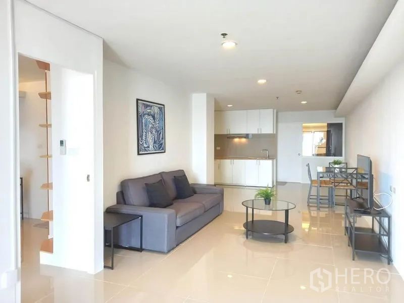 公寓 出租在Khlong Toei, Bangkok - 客厅面向白色小厨房与餐桌，采光充足。