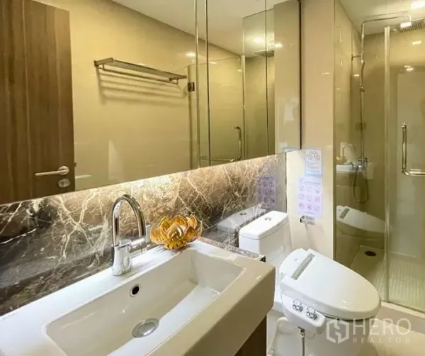 คอนโด ให้เช่า - ห้องน้ำสไตล์โมเดิร์น พร้อมส่วนอาบน้ำกระจกกั้น ผนังหินลาย และอ่างล้างหน้า