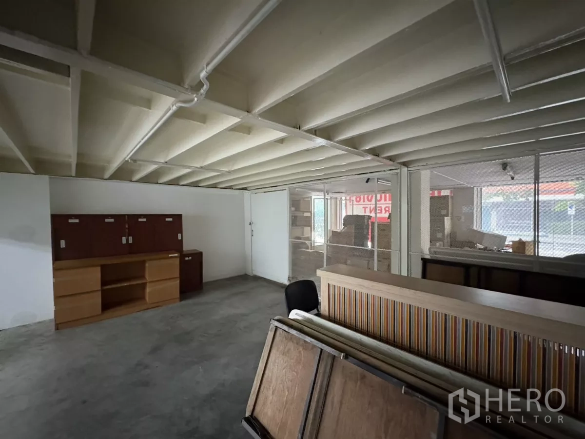 办公空间 出租在Watthana, Bangkok - 底层房间，裸露梁顶与玻璃隔断。