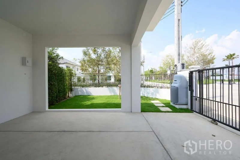 Detached House for rent or sale in Bang Phli, Samut Prakan - Covered carport looking out to a gated front lawn and street.