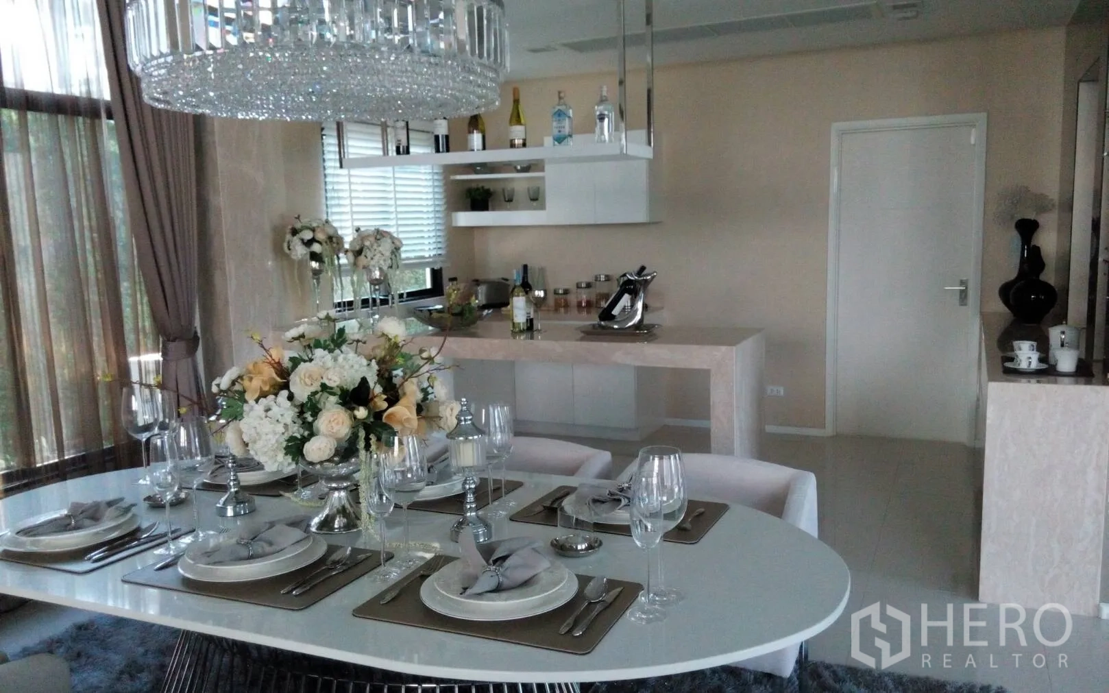 Detached House for rent or sale in Prawet, Bangkok - Elegant dining area with chandelier beside an open kitchen and breakfast bar.