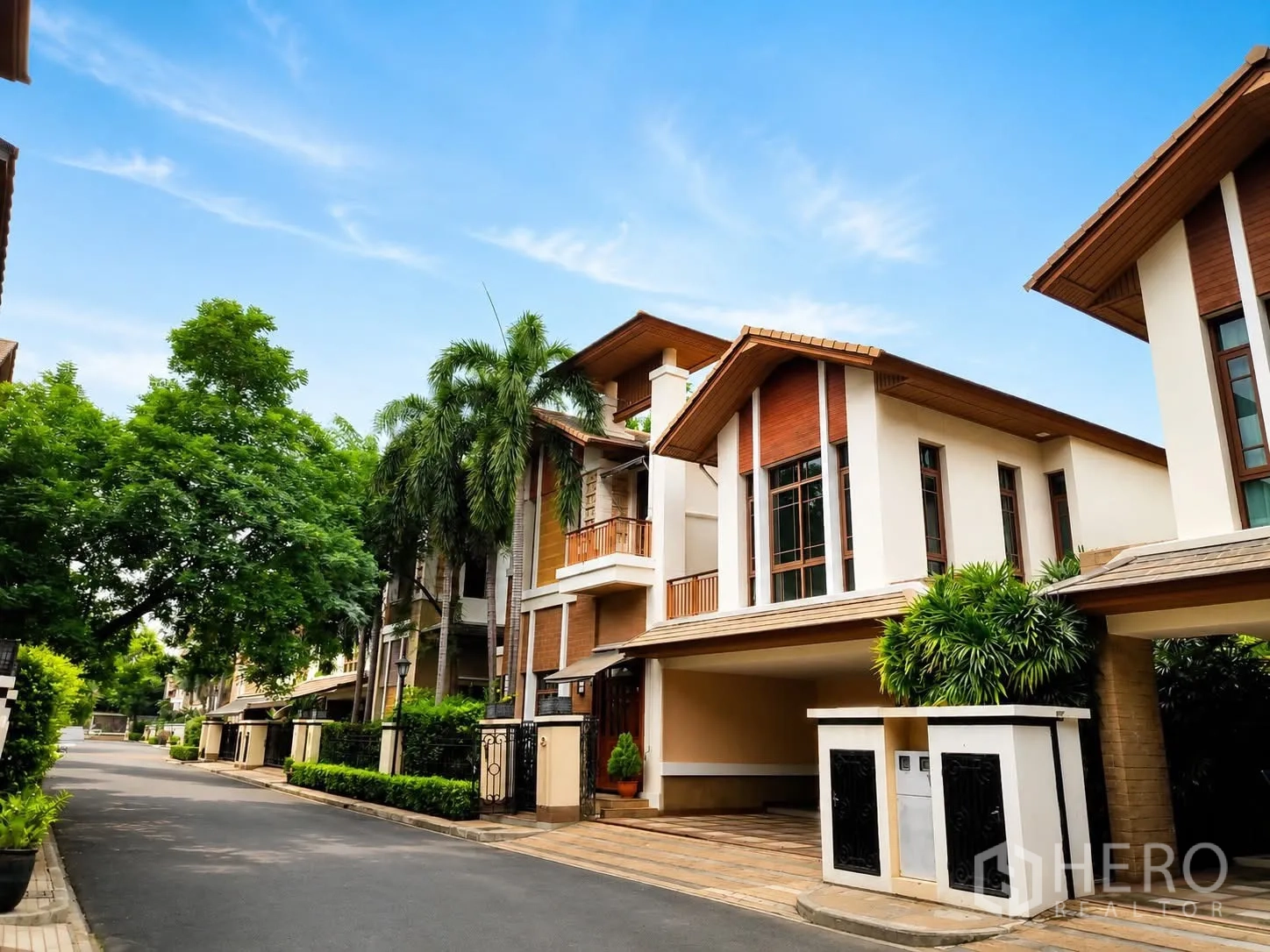 Detached House for rent in Watthana, Bangkok - Street view of contemporary detached houses with covered carports.