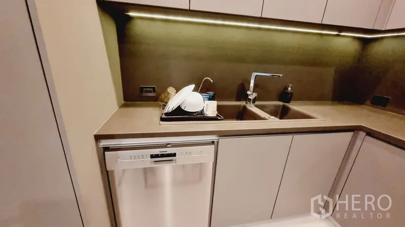 公寓 出售在Watthana, Bangkok - 现代化一体式厨房，带橱柜下照明、双水槽和洗碗机。