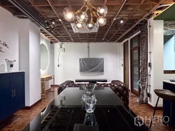 Apartment for rent in Khlong Toei, Bangkok - Dining and lounge area featuring a modern chandelier, exposed ceiling, parquet floors and built-in air conditioner.
