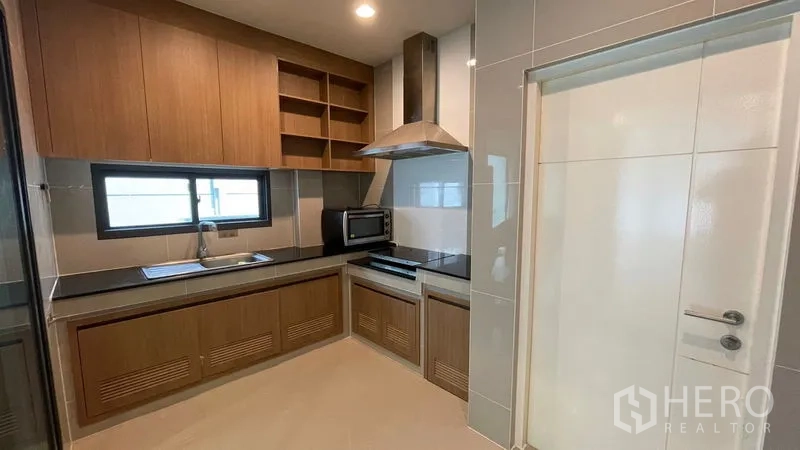 บ้าน ให้เช่าในBang Kapi, Bangkok - ห้องครัวบิวท์อิน ตู้ไม้ ท็อปดำ เครื่องดูดควัน และหน้าต่าง