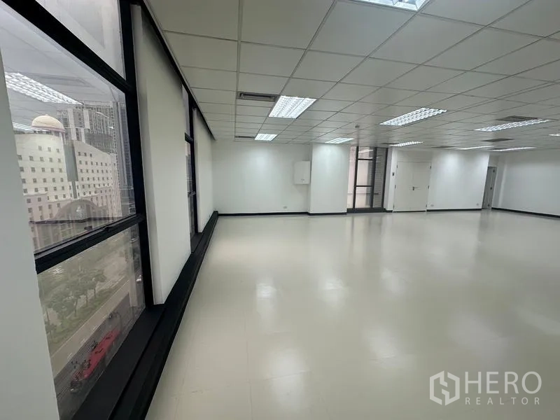 สำนักงาน ให้เช่า - พื้นที่สำนักงานแปลนเปิดโล่ง สว่าง มีหน้าต่างบานใหญ่ มองเห็นวิวเมือง ผนังสีขาว ฝ้าทีบาร์และไฟฟลูออเรสเซนต์