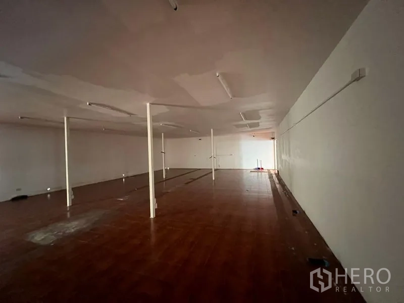 Warehouse for rent in Saphan Sung, Bangkok - Large enclosed storage room with lighting and support columns.