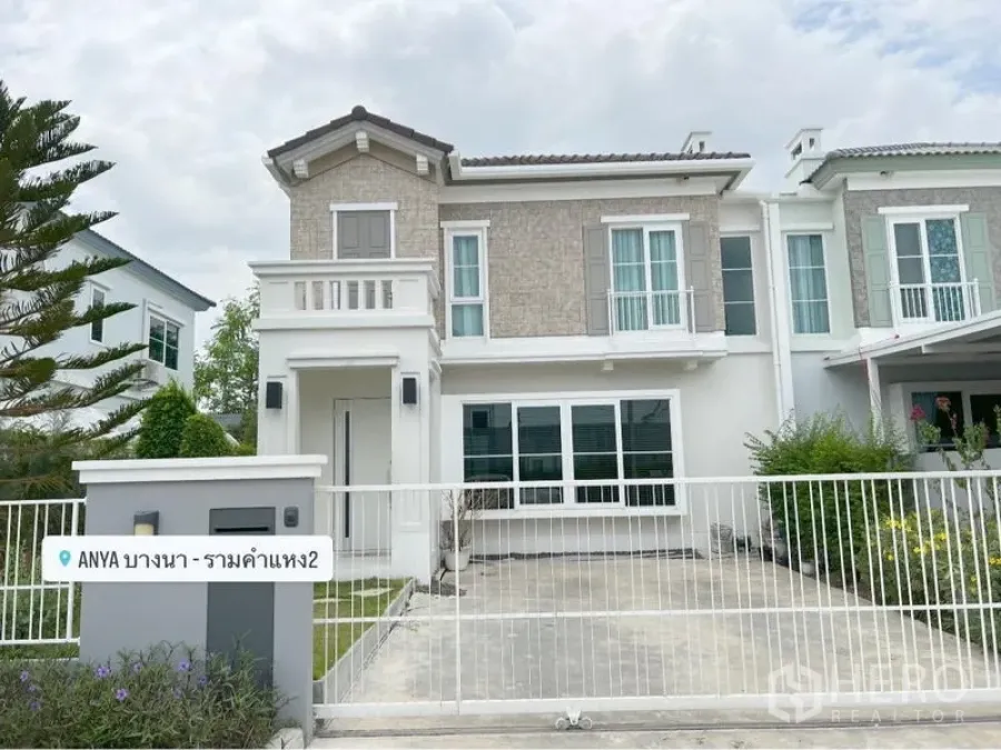 Detached House for rent or sale in Prawet, Bangkok - Front elevation of the house showing driveway, fence and landscaped hedges.