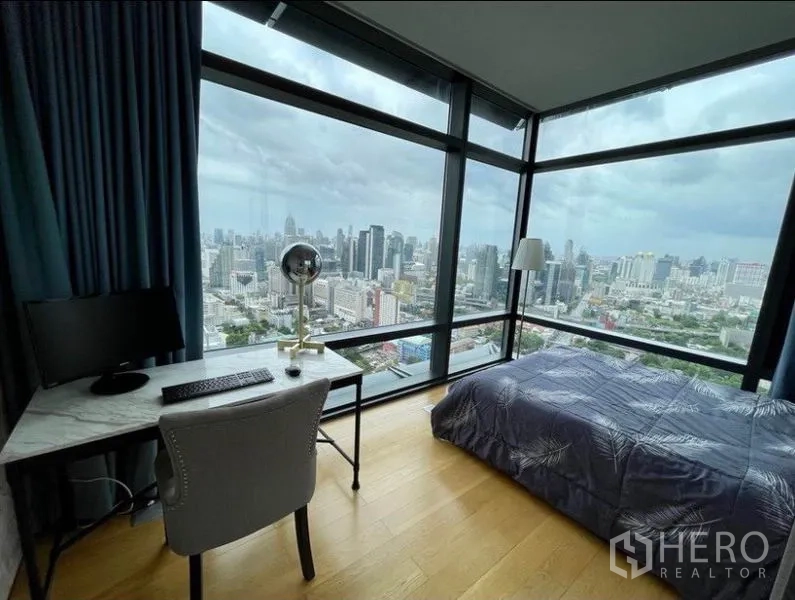 公寓 出售在Ratchathewi, Bangkok - 第二卧室设学习桌与转角落地窗，城市全景尽收眼底。