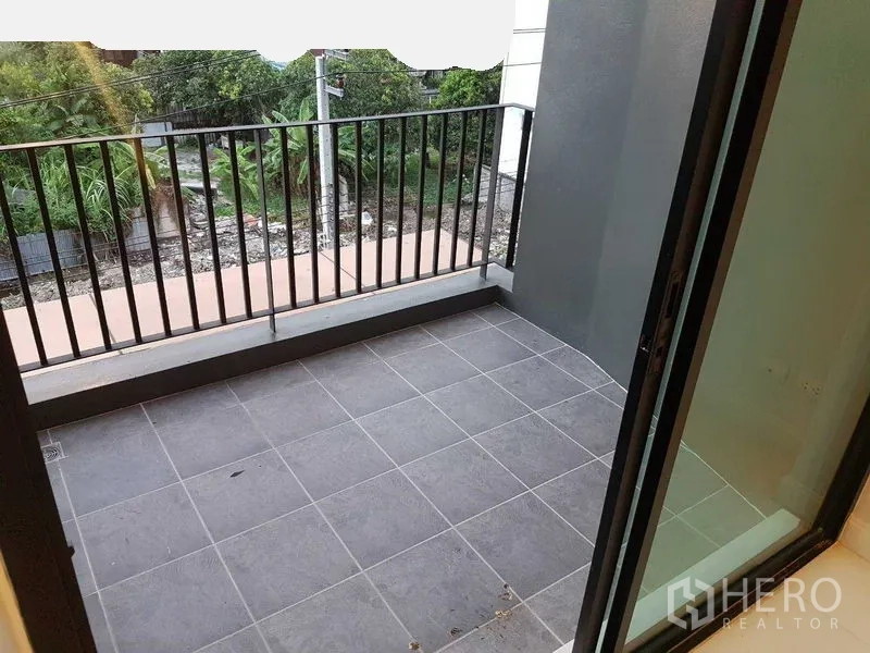 店屋 出租或出售在Bang Na, Bangkok - 私人阳台，灰色地砖与黑色栏杆，眺望绿意。
