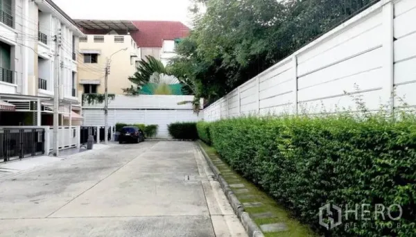 Townhouse for rent in Wang Thonglang, Bangkok - Quiet townhouse lane inside the compound with hedges, gated homes, and off-street parking.