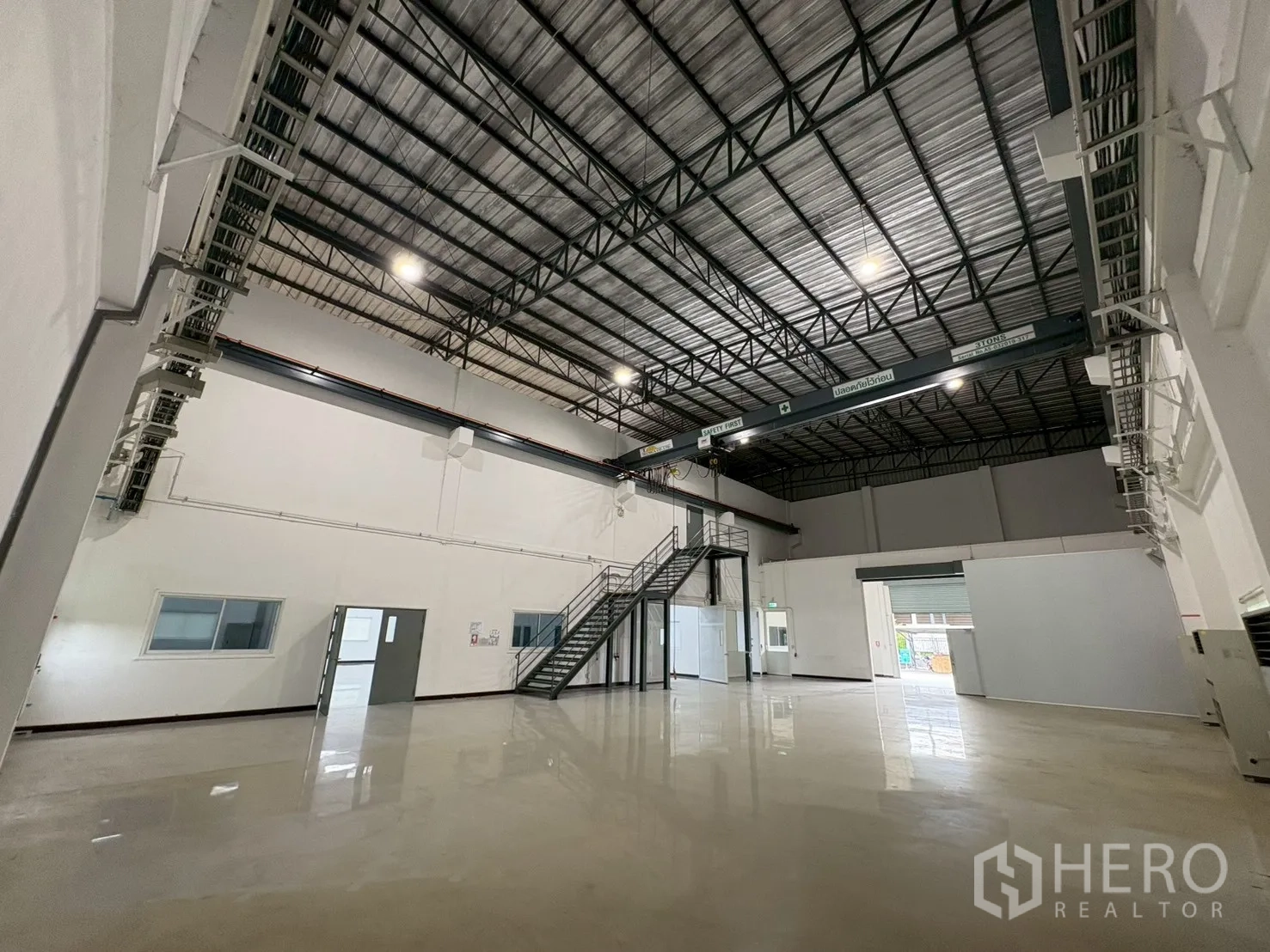 Factory for sale in Bang Bo, Samut Prakan - Spacious high roof hall showing crane rails, windows and entry bay.