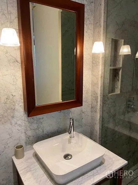 公寓 出租在Watthana, Bangkok - 大理石卫浴，方形台盆、木框镜与壁灯。