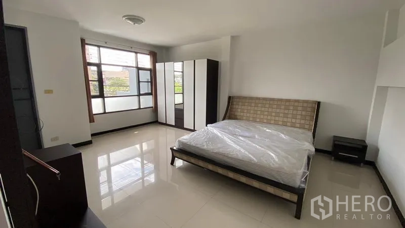 联排别墅 出租在Bang Na, Bangkok - 明亮卧室，双人床、衣柜与大窗户。