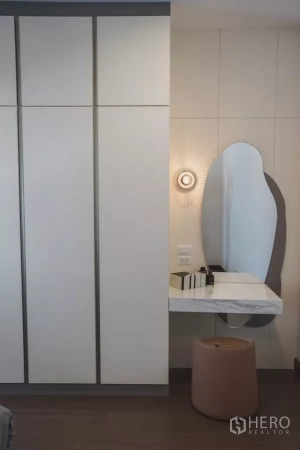 Detached House for rent in Bang Phli, Samut Prakan - Bedroom corner with full-height wardrobes and a floating marble vanity with curved mirror.